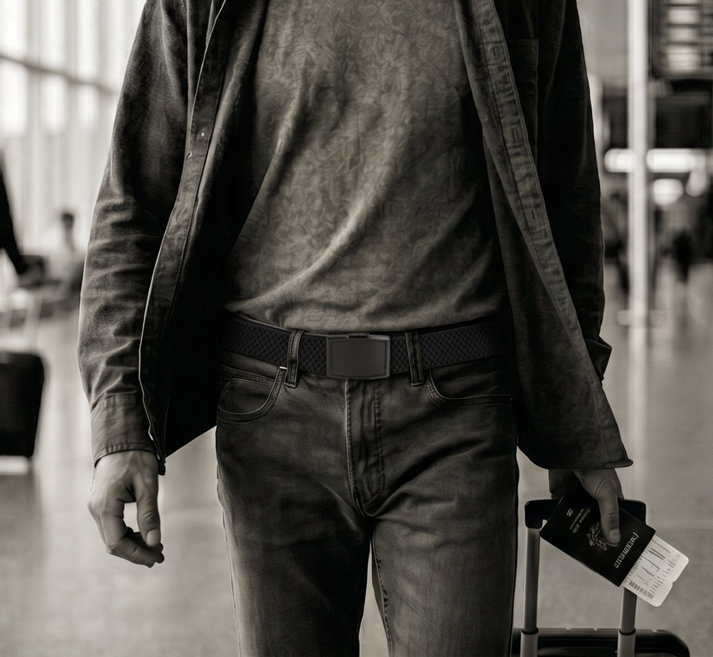 A traveller wearing a Flexy belt walking through an airport departures hall with a suitcase and boarding pass