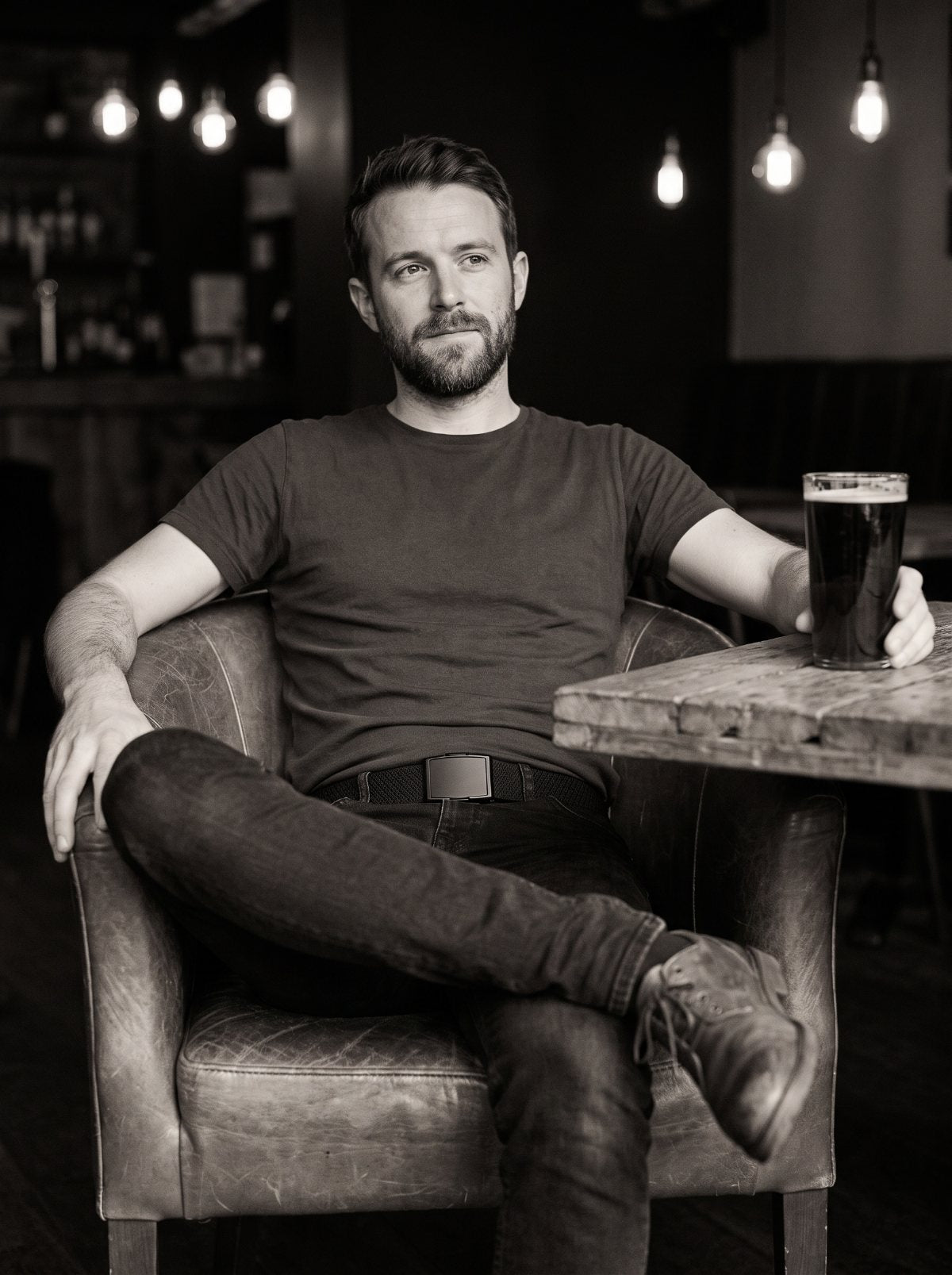 A man seated on a concrete ledge wearing the Flexy belt